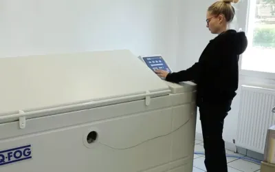 Opératrice devant une enceinte de brouillard salin