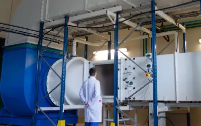 Technicien devant l'accès au banc d'essais sable et poussières